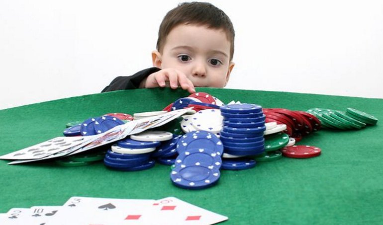 Un bambino con carte e fiches del casinò